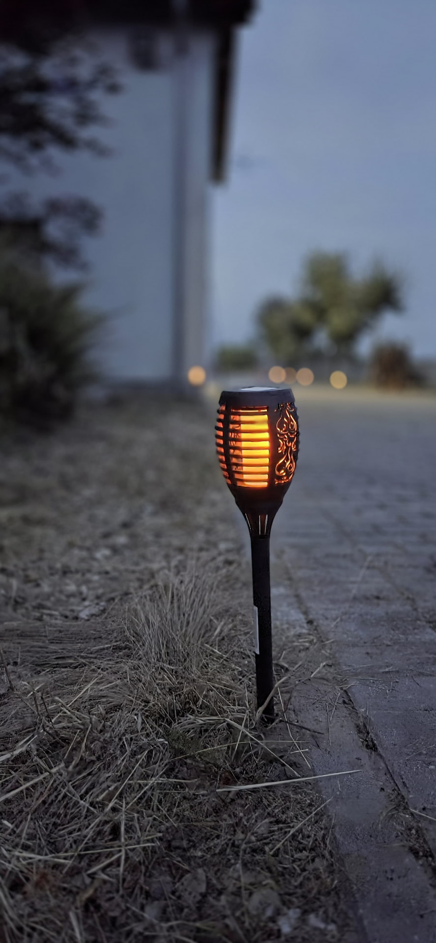 Solarna pochodnia rozświetlająca alejkę o zmierzchu w Korzeniach